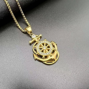 Macro shot of gold plated hip hop anchor pendant with inlaid zircons and steering wheel detail