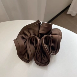 Detailed close-up of dark brown satin scrunchie with rich folds and silky luster