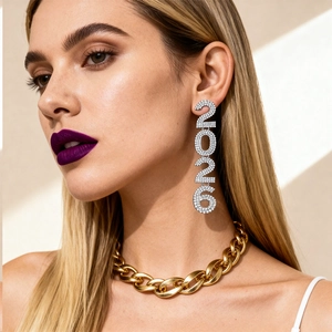 Close-up of sparkling rhinestone-studded 2026 number earrings on a female model