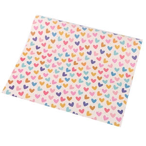 Detail shot of gift wrapping paper featuring colorful hand-drawn heart patterns