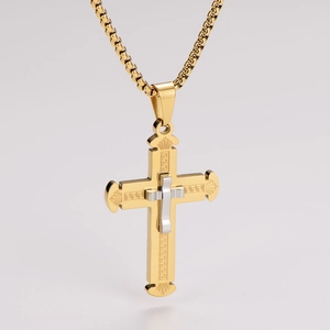 Detail view of double-layer gold and silver cross pendant with Greek key pattern