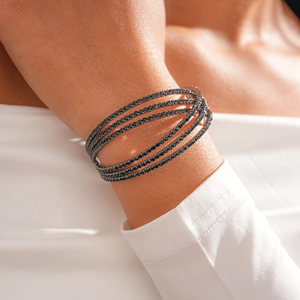 Detailed close-up of a five-layer crisscross bangle set with black round-cut stones