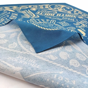 Close-up of cotton bandanna with blue nautical print and white navigation compass patterns