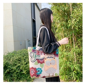 Close-up of double-sided jacquard tote bag with cat owl embroidery and cotton rope handles