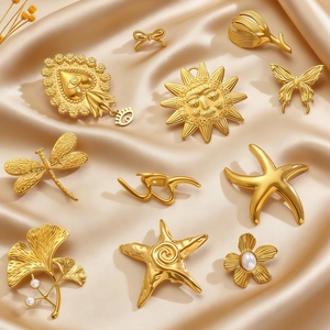 Vintage gold brooches and pendants collection featuring sun mask and heart designs on silk