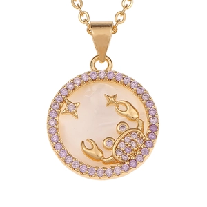 Close-up of golden Cancer zodiac pendant with white mother of pearl and purple gemstones