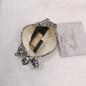 Trousse à maquillage fleurie en toile avec fermeture éclair et motifs blancs sur noir