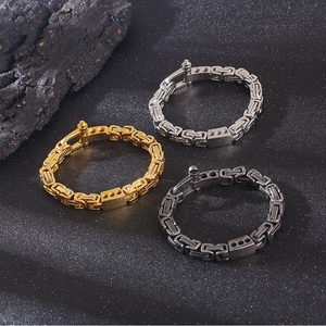 Three Byzantine chains in gold, silver, and black metal on textured dark stone
