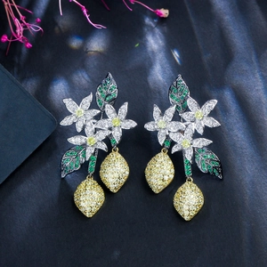 Macro detail of silver floral earrings with yellow lemon charms and sparkling zircon crystals