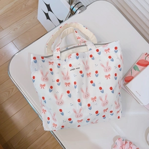 Cute bunny and tulip print canvas tote bag with Simple Wish label on white desk