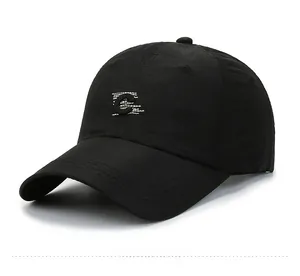 Detail of black baseball cap featuring letter C embroidery and reinforced visor stitching