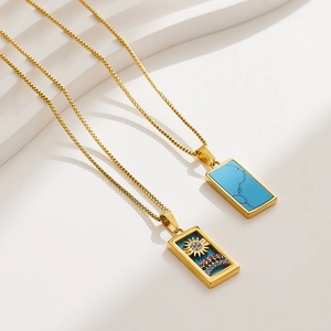 Detail of gold tarot necklaces with turquoise inlay and colorful sun rainbow pendants