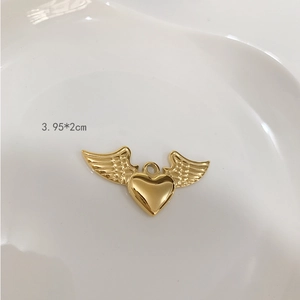 Macro shot of gold-plated titanium heart pendant with wings and size info 3.95x2cm