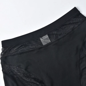 Detail of high-waisted black athletic shorts with breathable mesh panels and stitching