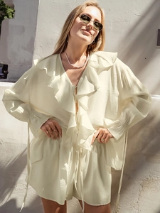 Détail du chemisier à volants jaune clair avec col en V sous la lumière naturelle