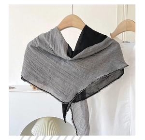 Detail of grey and black color-block cotton scarf with crinkle texture and crochet lace