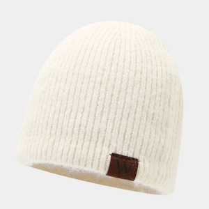 Detail of off-white knitted beanie featuring fine texture and a brown square label with 'W'