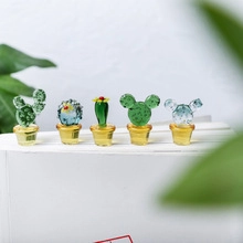 Macro shot of glass stir sticks featuring green cactus and mouse-shaped heads in yellow pots