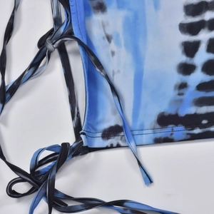 Close-up of blue and black tie-dye dress featuring side drawstring and seam details