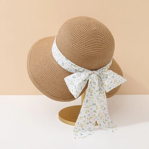 Gros plan du chapeau de paille avec ruban fleuri bleu sur un support d'exposition