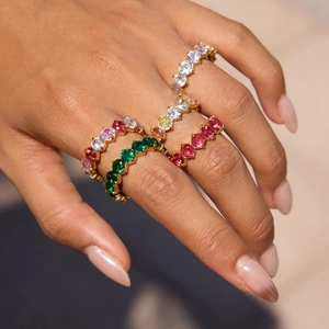 Close-up of sparkling eternity bands with colorful round-cut zircons in gold-plated steel