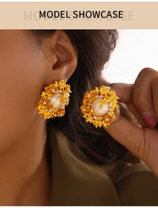 Close-up of vintage gold floral cluster earrings with pearls worn by a model