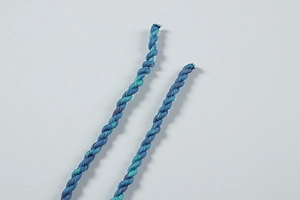 Vue macro du cordon en soie dégradé bleu et vert montrant la texture du tissu