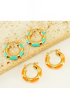 Detail of 18K gold-plated wavy hoop earrings with sky blue and orange enamel inlays