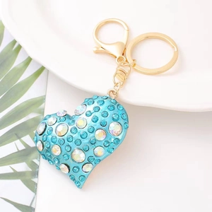 Detailed view of a blue heart keychain with crystals and gold lobster clasp decoration