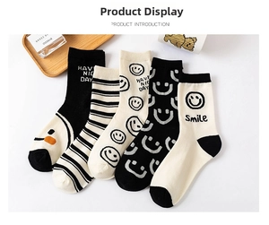 Flat lay of five pairs of cotton socks featuring smiley faces, stripes and letters