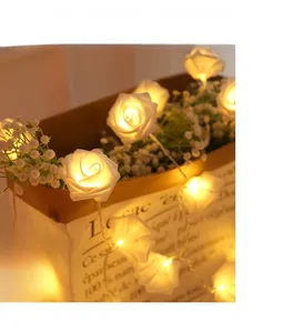 Close-up of LED rose flower string lights with warm glow on a decorative paper bag