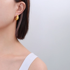 Close-up of elegant gold crescent horn earrings on model showing polished finish and curve