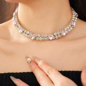 Gros plan du collier double rang avec cristaux de cœur roses et strass sur le mannequin