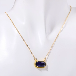 Detail einer Goldkette mit horizontalem ovalem blauem Edelsteinanhänger auf einer Büste