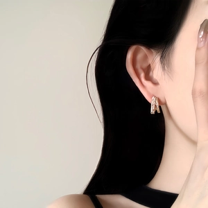 14k gold plated geometric stud earrings with pavé crystals on elegant model