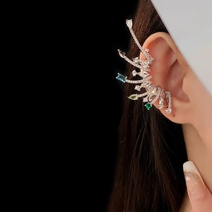 Detailed macro view of silver ear cuff with colorful gemstones on model ear