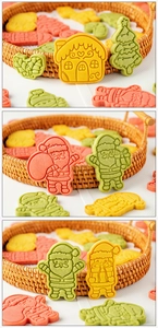 Close-up of colorful gingerbread house and Santa cookie cutters on a woven tray