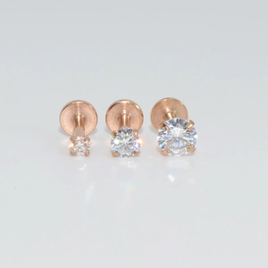 Tres piercings labret en oro rosa con circonitas de diferentes tamaños en fondo blanco