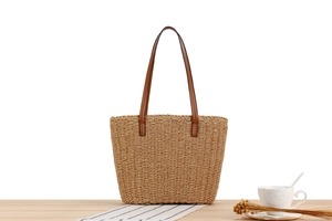 Detail der handgewebten Papierschnur-Tasche mit braunen Lederriemen und Textur