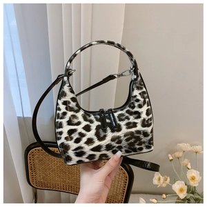 Detail shot of black and white leopard print hobo bag in glossy patent leather finish