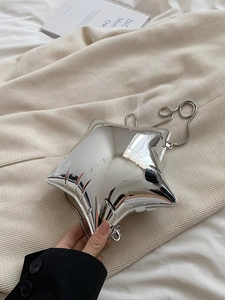 Macro detail of star shaped silver crossbody bag featuring a metallic crinkled texture
