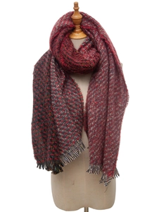 Detail of red and black checkered knit scarf with fringe trim on a white background