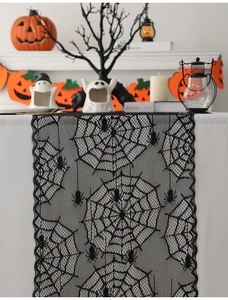 Detail of black lace spider web runner with pumpkins and ghosts for Halloween decor