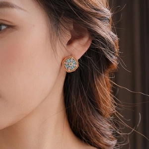 Vintage gold plated flower earring with colorful enamel on a model for a stylish look