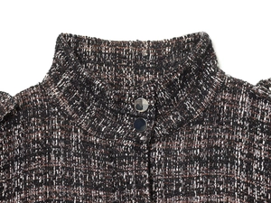 Detail of tweed bomber jacket showing stand collar and silver metal buttons on metallic fabric