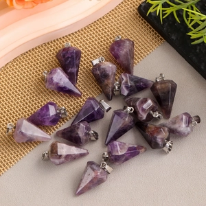 Polished amethyst faceted cone crystal pendants with silver metal bails on a textured background
