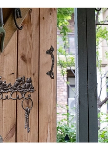 Close-up of seahorse door handle and frog hooks in vintage bronze cast iron