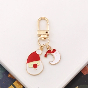 Detailed view of gold metal keychain with Santa Claus and red crescent enamel charms