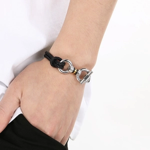 Men's woven leather bracelet featuring a silver horseshoe buckle and gold accents