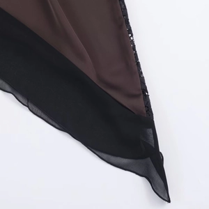 Detailed view of dark brown satin dress with sheer chiffon and black lace paneling